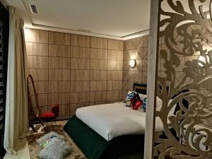 sypialnia z łóżkiem z wzorem drzewa na ścianie w obiekcie Hôtel Volubilis Meknès w mieście Meknès
