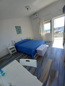 1 dormitorio con cama azul y suelo de madera en Da Angelo, en Borgo