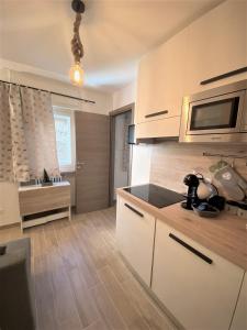 une cuisine avec des armoires blanches et un évier dans l'établissement Casa Sestriere - bilocale in centro a Sestriere, à Sestrières