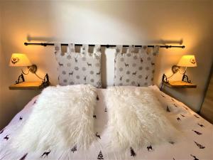 - un lit avec des oreillers en fourrure blanche et 2 lampes dans l'établissement Casa Sestriere - bilocale in centro a Sestriere, à Sestrières