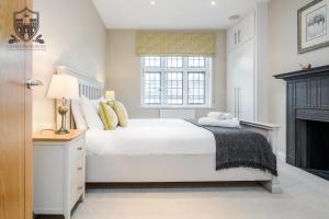 a white bedroom with a bed and a fireplace at Castle Properties:Eton-The College in Windsor