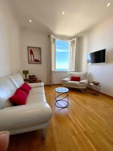 ein Wohnzimmer mit einem weißen Sofa und 2 Stühlen in der Unterkunft Amazing view - Monaco in Cap d'Ail
