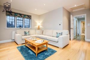 a living room with a white couch and a table at Castle Properties:Eton-The College in Windsor