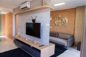 a living room with a couch and a flat screen tv at Apto 2 suites com elevador no Frances -Adm Nutelss in Praia do Frances