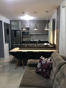 a living room with a couch and a kitchen at Beach House Nascer do Sol in Florianópolis