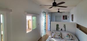 um quarto com uma cama e uma ventoinha de tecto em Ocean Shore em Philipsburg