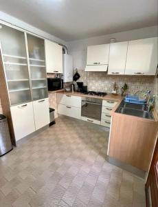 Il comprend une cuisine avec des placards blancs et du carrelage. dans l'établissement Appartement T3 spacieux et lumineux de 70m2, à Bastia