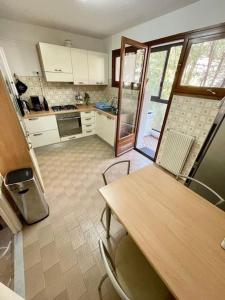 Il comprend une cuisine avec une table et des chaises en bois. dans l'établissement Appartement T3 spacieux et lumineux de 70m2, à Bastia