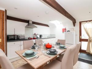 a kitchen with a wooden dining table and chairs at Wheal Prosper in St Austell