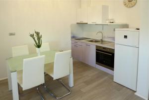 a kitchen with a table with chairs and a sink at Apartments Sunset in Olib