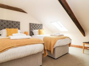 two beds in a attic bedroom with white and orange at The LinneyThe West Dry in St Austell