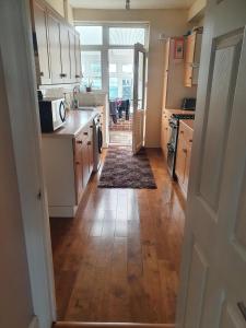 a kitchen with wooden floors and a kitchen with a microwave at Croydon - Compton in South Norwood