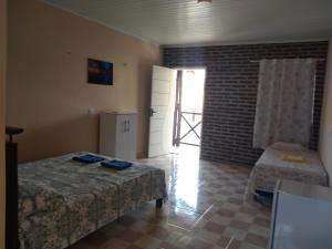 a room with two beds and a door with a window at Laggon Residence in Jijoca de Jericoacoara