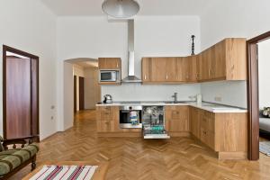 a kitchen with wooden cabinets and a living room at Mamma's Apartment in Budapest