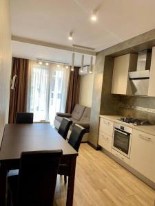 Il dispose d'une cuisine et d'un salon avec une table, une cuisine et un canapé. dans l'établissement Апартаменти в новобудові, à Lviv