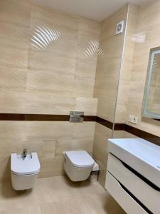 La salle de bains est pourvue de toilettes blanches et d'un lavabo. dans l'établissement Апартаменти в новобудові, à Lviv