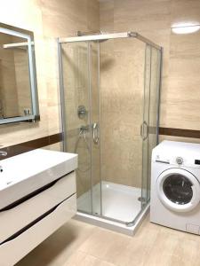 La salle de bains est pourvue d'une douche et d'un lave-linge. dans l'établissement Апартаменти в новобудові, à Lviv