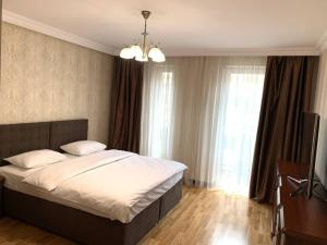 - une chambre avec un grand lit et un lustre dans l'établissement Апартаменти в новобудові, à Lviv