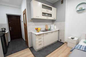 una pequeña cocina con armarios blancos y fregadero en Apartament Estakada en Częstochowa