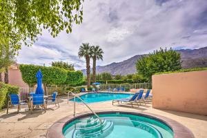a swimming pool with chairs and a palm tree at Resort Amenities Updated Palm Springs Villa in Palm Springs