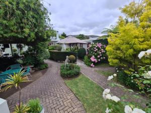 a garden with a brick walkway with flowers and plants at Knysna Self Catering Accommodation in Knysna