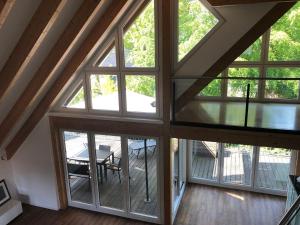 an attic room with large windows and a table at Ferienloft Dalum in Geeste