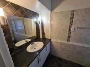 a bathroom with two sinks and a shower with a mirror at Knysna Self Catering Accommodation in Knysna