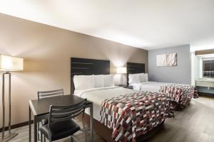 a hotel room with two beds and a table at Red Roof Inn & Suites Athens, AL in Athens +29 photos