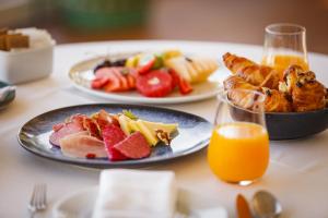 a table with two plates of food and a glass of orange juice at InterContinental Cascais-Estoril by IHG in Estoril