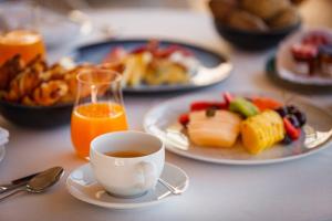 a table with plates of food and a cup of coffee at InterContinental Cascais-Estoril by IHG in Estoril
