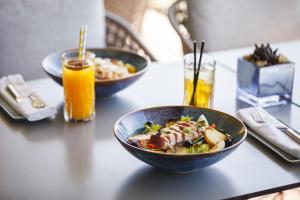 a table with two bowls of food and orange juice at InterContinental Cascais-Estoril by IHG in Estoril