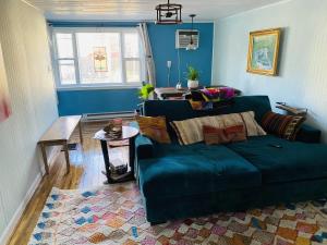 ein Wohnzimmer mit einem blauen Sofa und einem Tisch in der Unterkunft Boho-Chic Travel Pad - Unit 2 in Bloomington