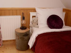 ein Schlafzimmer mit einem Bett mit einem Teddybär drauf in der Unterkunft Sołtysówka in Wielogłowy