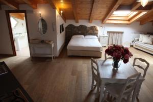 a bedroom with a bed and a table with flowers on it at Casa Trauner Mansarda Saba in Trieste