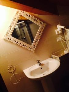 łazienka z umywalką i lustrem na ścianie w obiekcie Casa Trauner Mansarda Saba w Trieście