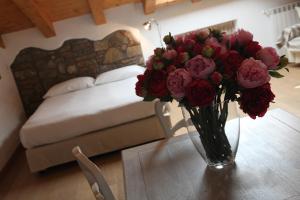 a vase of flowers on a table in a bedroom at Casa Trauner Mansarda Saba in Trieste