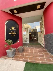 薩爾雷的住宿－Hotel Dunas Ilha da Boavista Sal Rei，红色的建筑,上面标有读酒店堂加斯的标志