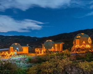 a group of domes in a field at night at Los Nopales Glamping in Sáchica