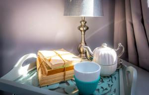 a table with a tea pot and a book on it at Secret Garden Miami Beach in Miami Beach