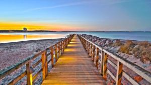 una passerella in legno sulla spiaggia al tramonto di 4Hafenzeiten - Ferienwohnung NIE 13 Eva a Timmendorfer Strand