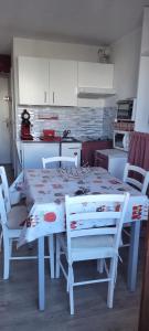 a white table and chairs in a kitchen with a table at Appartement sur le Parc des Ecrins in Puy-Saint-Vincent