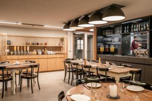 a restaurant with tables and chairs and a bar at Carina - Design&Lifestyle hotel in Zermatt