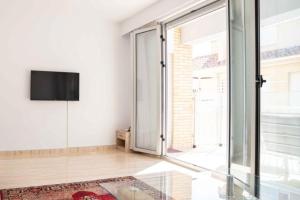 un soggiorno con TV e ampia finestra di Beautiful Two Bedroom Apartment next to the beachfront a La Horadada