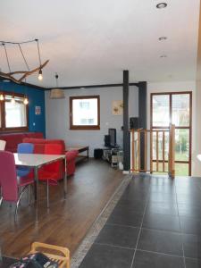 un soggiorno con divano rosso e tavolo di Agréable maison à la campagne a Schlierbach