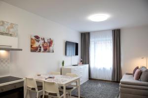 a kitchen and living room with a table and a couch at Cute apartman- free parking in Pécs