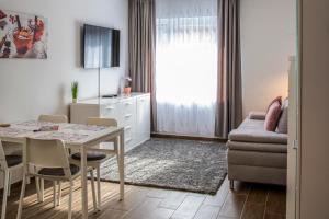a living room with a table and a couch at Cute apartman- free parking in Pécs
