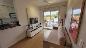 a living room with a couch and a large window at Apartamento 50m2 Hospital Einstein Morumbi in Sao Paulo