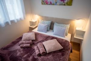 a bedroom with a large bed with towels on it at Cute apartman- free parking in Pécs