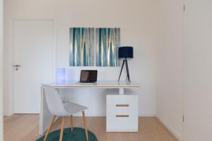 a white desk with a laptop and a chair at Appartements du comte de Dabo in Dabo