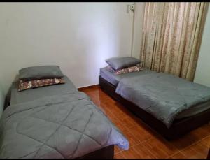 2 Betten nebeneinander in einem Zimmer in der Unterkunft Laguna Condo Resort Port Dickson in Port Dickson
